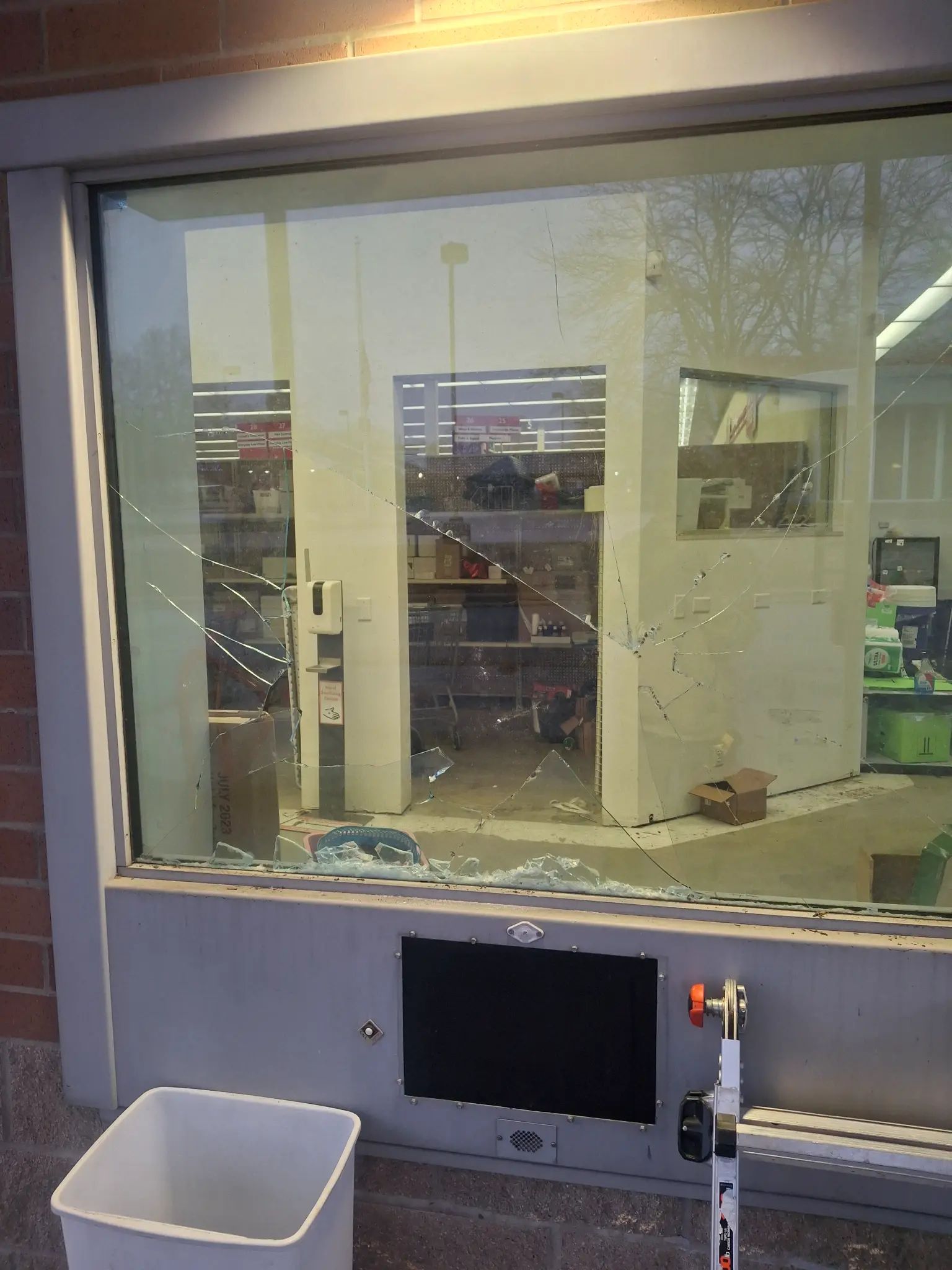 Smashed commercial storefront window — before emergency board-up