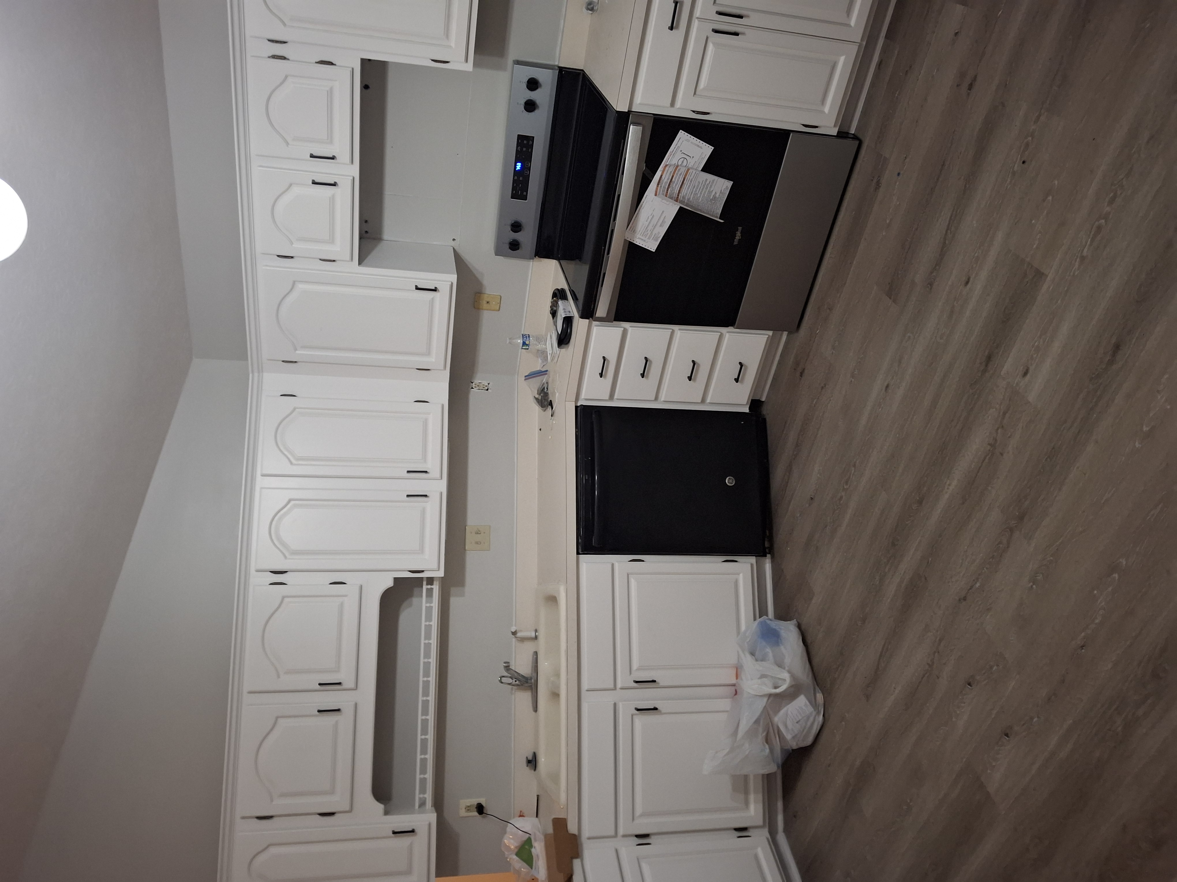 Before: Kitchen cabinets being stripped and painted