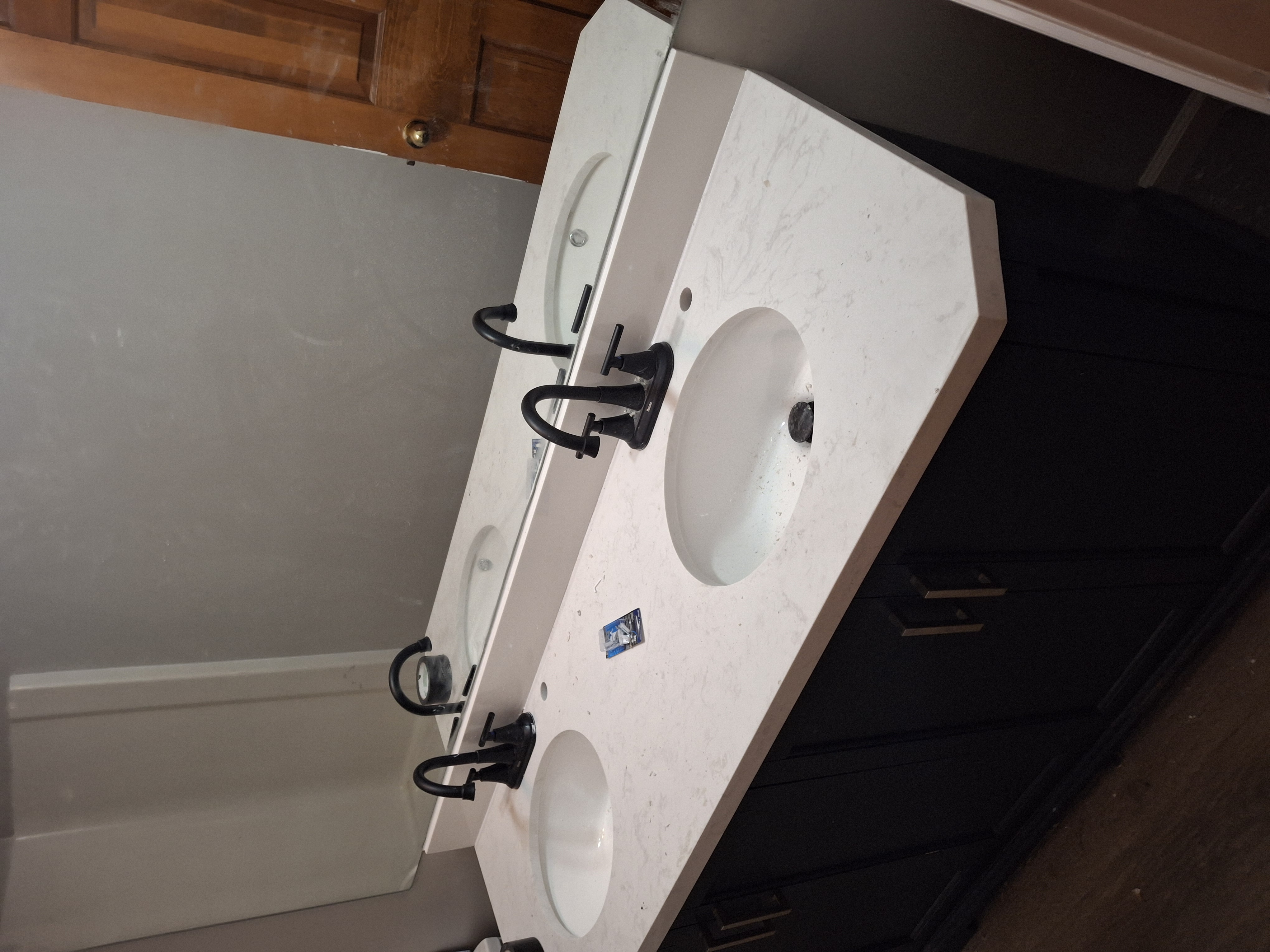After: Completed double bathroom vanity with quartz countertop and black fixtures