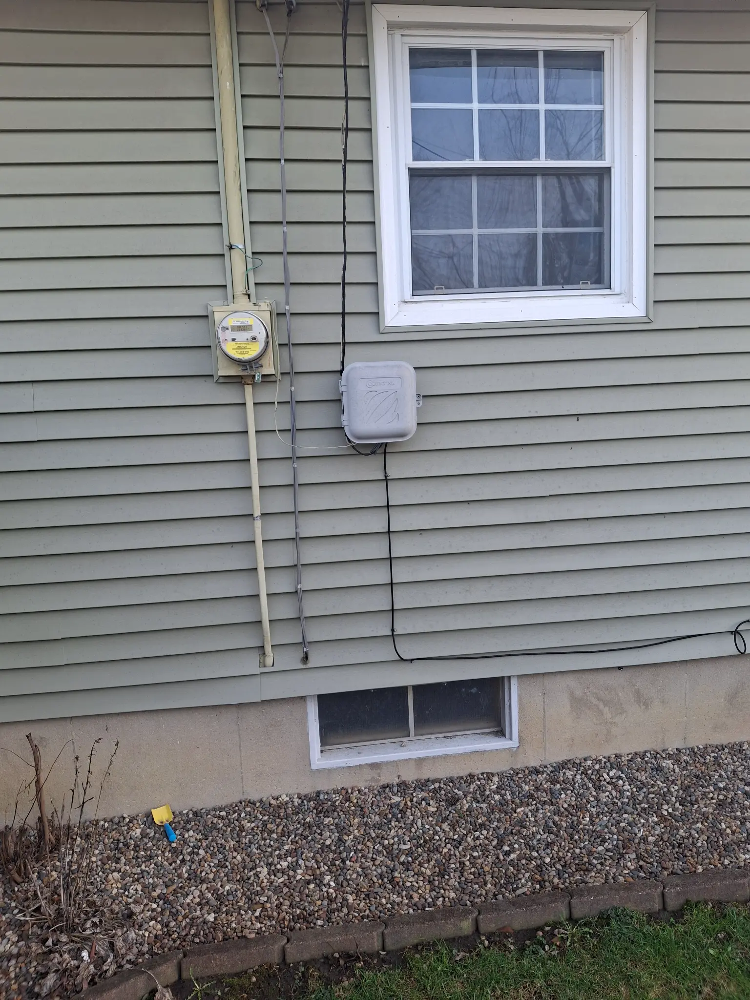 Vinyl siding installation on residential home exterior with trimmed window surround